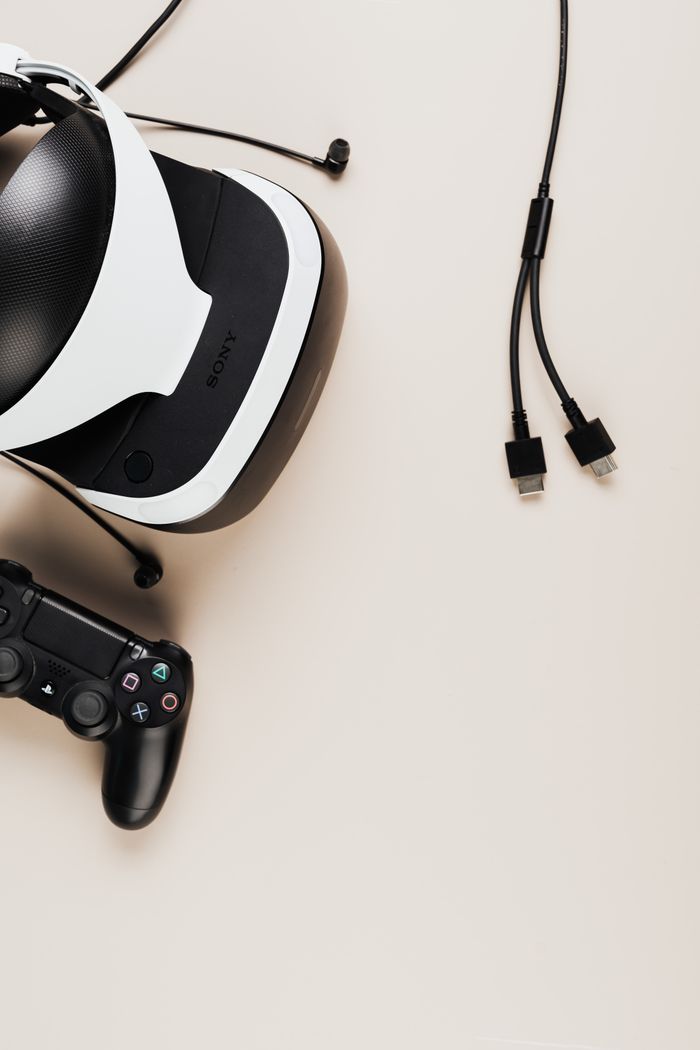 Modern VR headset and game controller on beige background with copyspace, perfect for gaming concepts.
